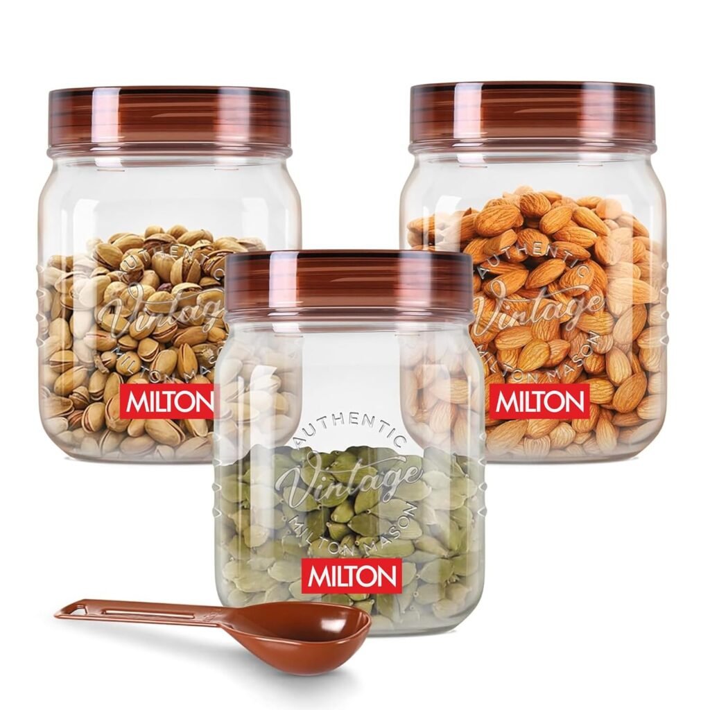 Milton Vintage airtight storage jars with transparent containers and brown lids, filled with almonds, pistachios, and pumpkin seeds, including a matching scoop.