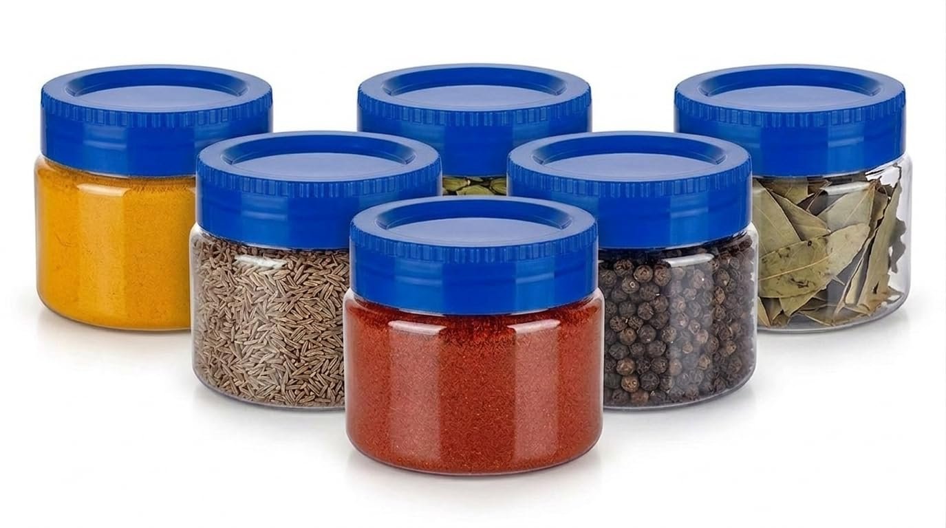 Clear spice storage jars with blue lids filled with assorted spices
