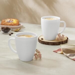 White ceramic coffee mugs with coffee served on a table